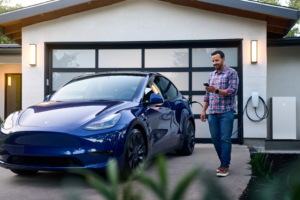 Een Tesla thuisbatterij Powerwall 3, en een man die een Tesla auto heeft